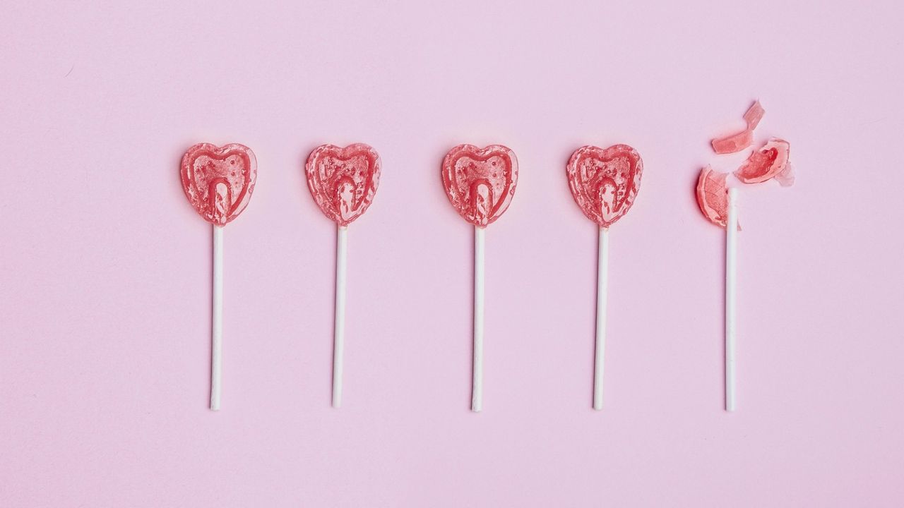 heart shaped lollypops in pink background