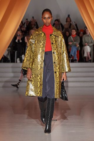 Woman on runway wearing snakeskin-print jacket