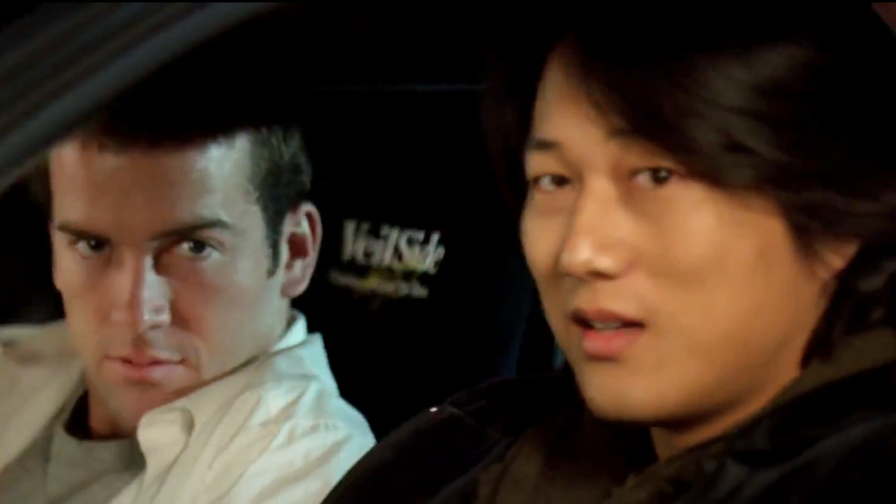Lucase Black y Sung Kang mirando desde su auto en The Fast and the Furious: Tokyo Drift.