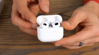 Person holding AirPods 3 clone
