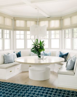 A banquet seating area with a round dining table and bay window