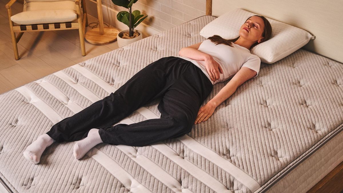 A woman sleeps on her back on the Leesa Studio Chill Mattress