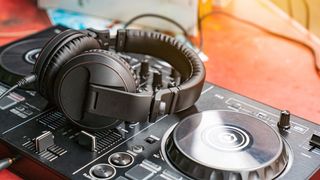 Pair of headphones laying on DJ decks