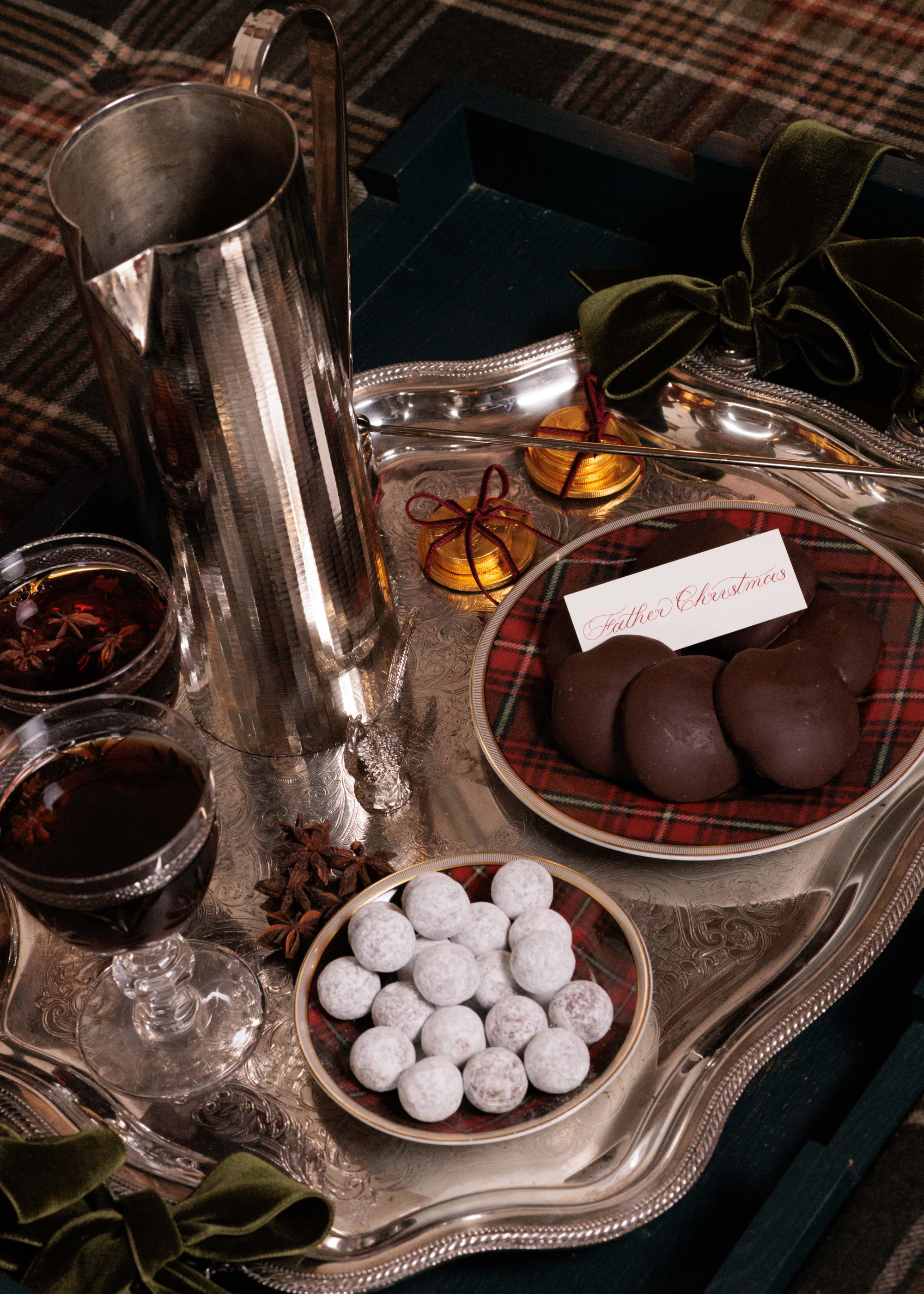 A serving tray with drinks, snacks and cookies on a table setting