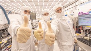 Three engineers give a thumbs up inside Intel's Fab 28.