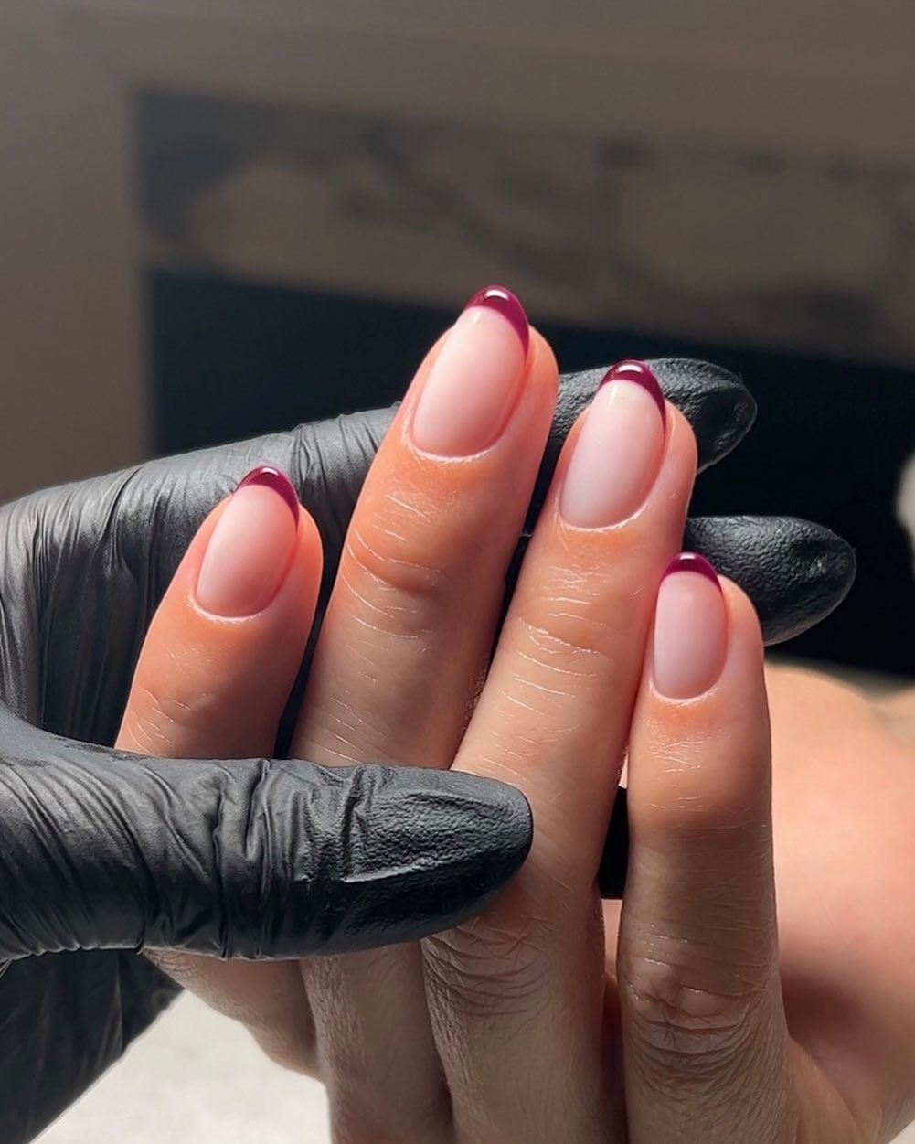 An almond-shaped, burgundy French tip manicure