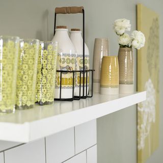 white wall shelf with white bottles and designed glasses