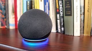 Echo Dot on desk with a stack of books behind it