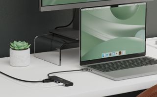 Plugable USBC-4IN1 USB Hub with 100w Power Delivery at a desk with a MacBook Pro