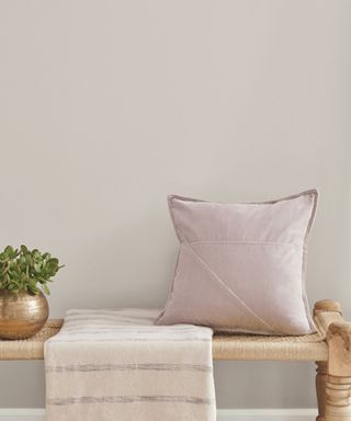 Neutral painted wall and pink throw pillow