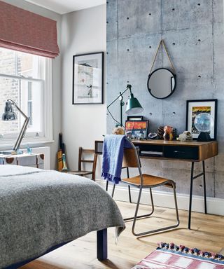 Bedroom with distinctive wallpaper walls, study space with wooden desk and chair