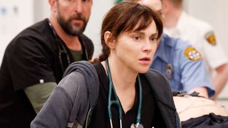 Cassie wheels a patient into theatre