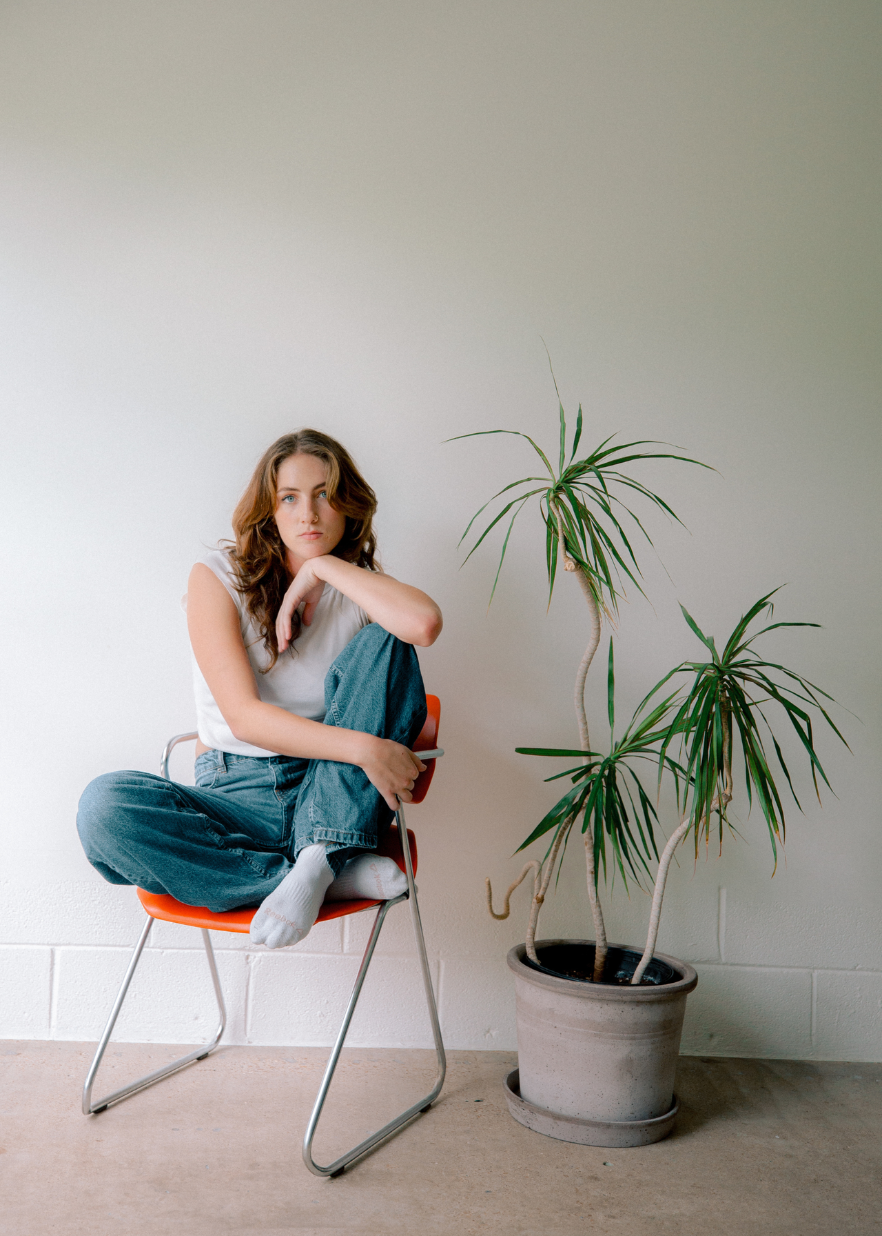 Savannah Toal, founder of Plant Savvy sitting beside a potted plant