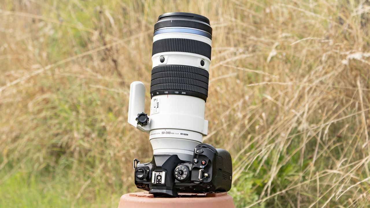 OM System M.Zuiko Digital ED 50-200mm F2.8 IS Pro lens attached to an OM-1 II, outdoors with long grass in the background