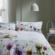 bedroom with floral printed bedding set and white wall
