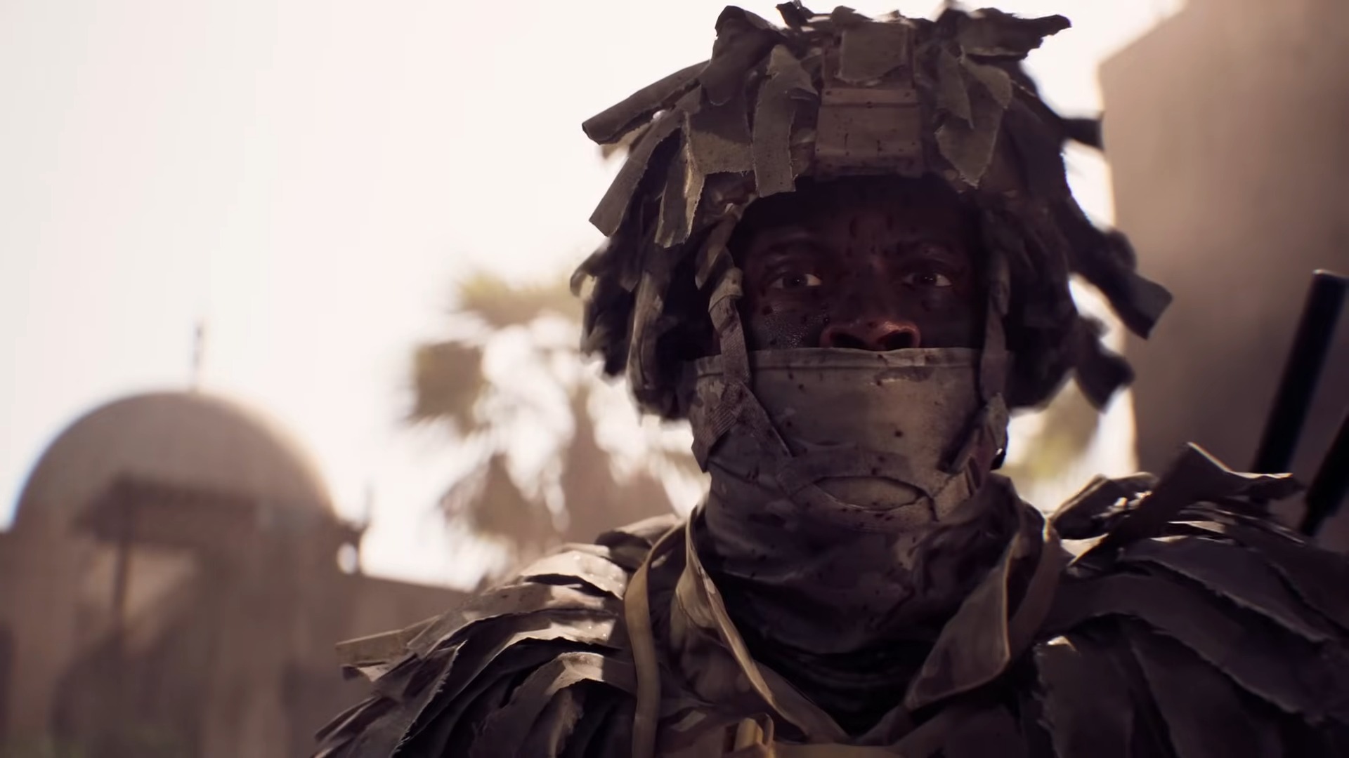 A close up of a soldier wearing a helmet and face mask staring at the camera