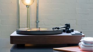 Lenco LBTA-165 turntable on grey desk with lamp