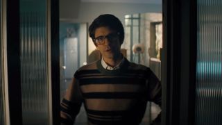 Ben Whishaw answering the door with a look of displeasure in No Time To Die.