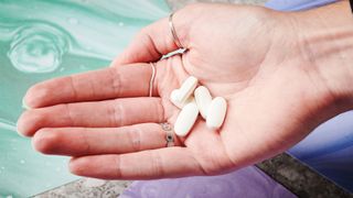 woman holding magnesium supplements in the palm of her hand