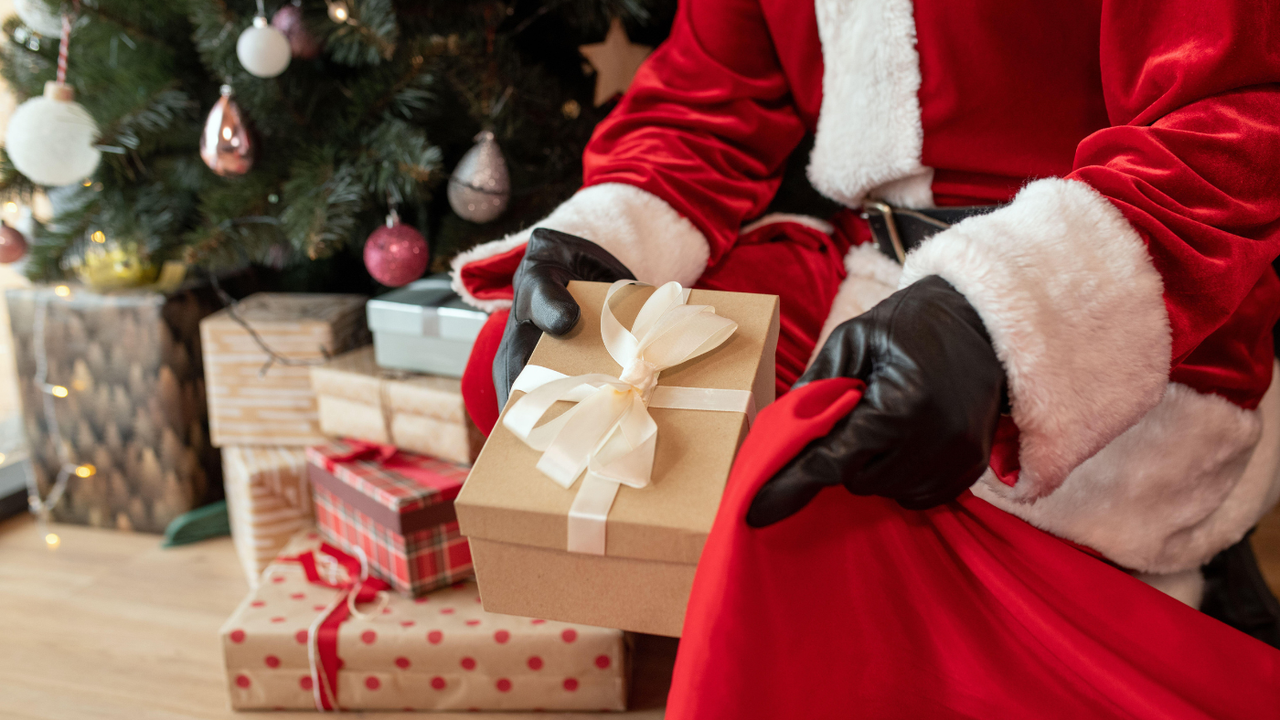 Santa Claus stuffing a present into a stocking