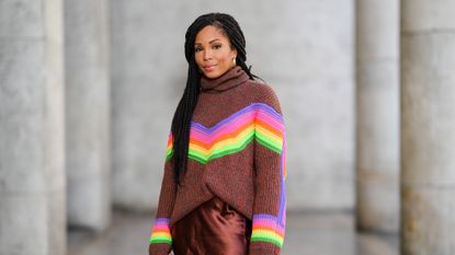 woman in colorful turtleneck sweater and brown skirt