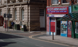 A Bolton street featuring Rico's Newsagents