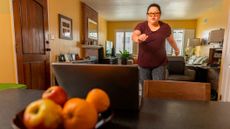 Woman exercising in front of a laptop at home