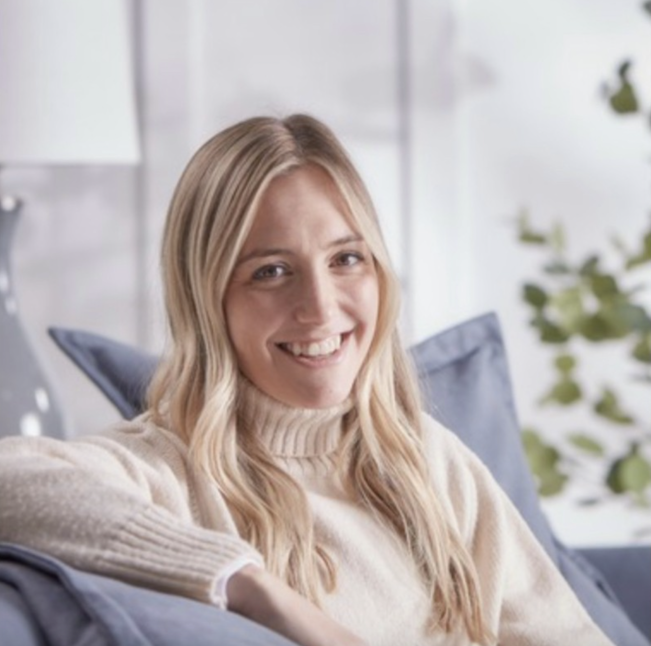 A headshot of a woman with long blond hair smiling at the camera