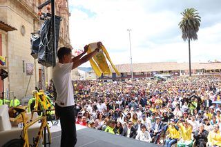 Egan Bernal shows his maillot jaune to the crowd