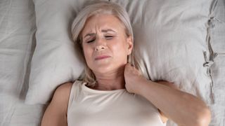 A woman sleeping on a pillow with neck ache