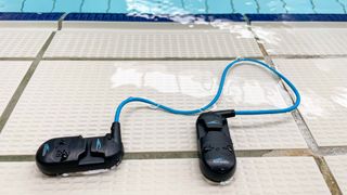 H2O Audio Sonar Underwater Waterproof Headphones on the poolside floor