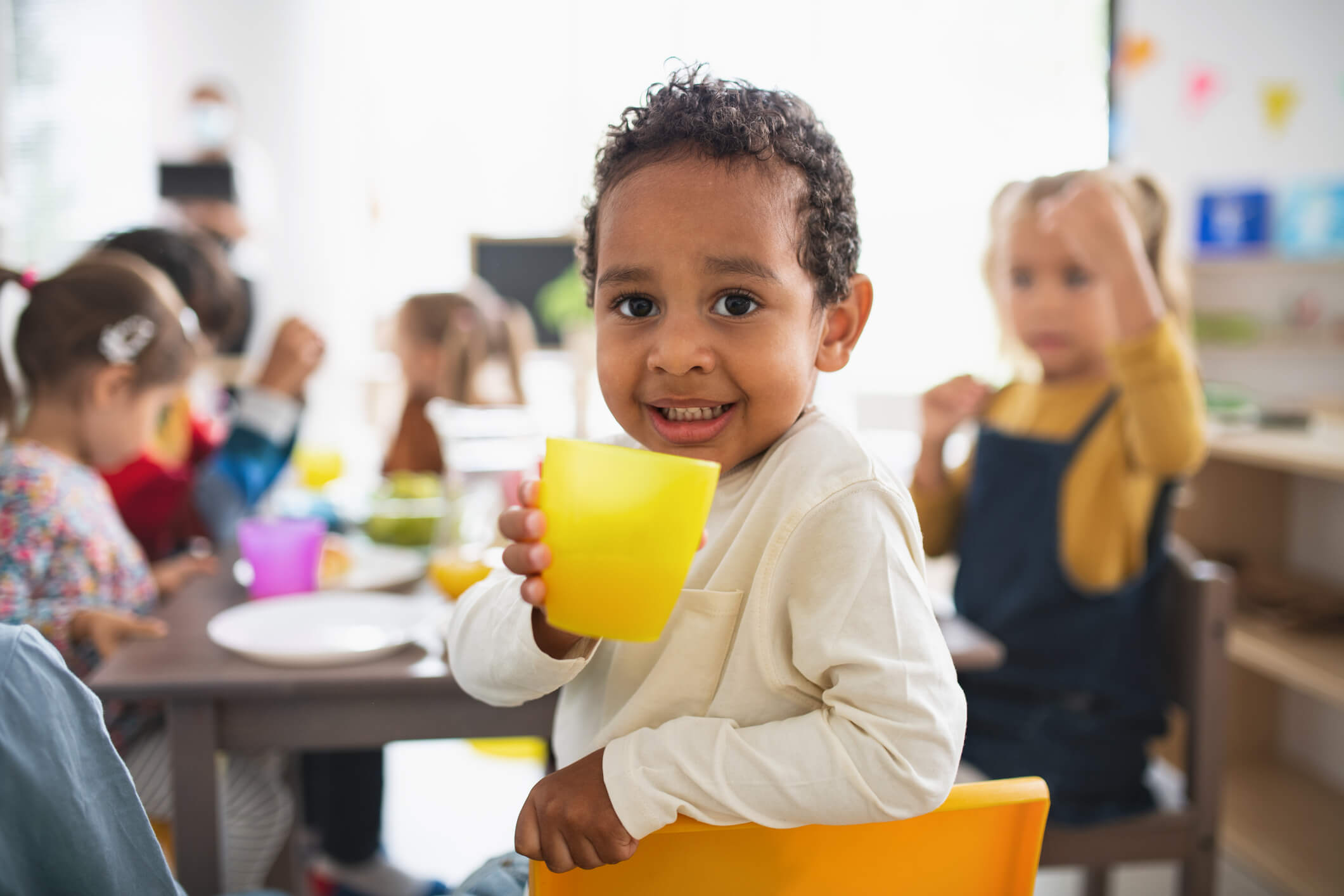 Group of small children having meal at kindergarten.