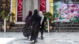 Three women enter a beauty salon in Afghanistan