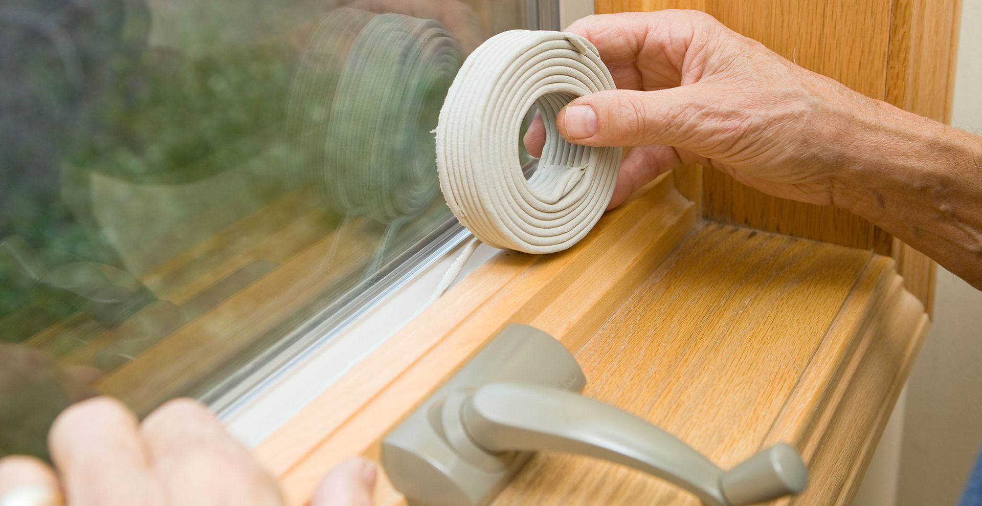 person caulking window cracks to show how to keep ants away