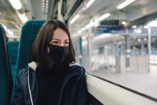 woman on train wearing face mask as London goes into Tier 4 lockdown restrictions