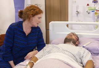 Fiz sits next to Tyrone Dobbs in a hospital bed