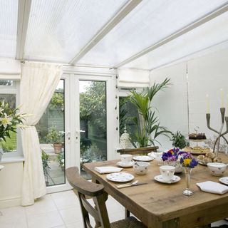 dining room with white tiled flooring and wooden table with chairs