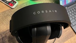 A Corsair HS80 USB on a headset holder on a desk