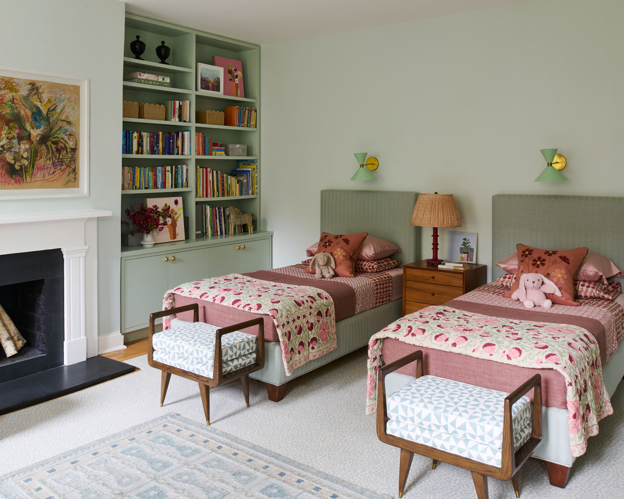 a twin bedroom with two beds next to each other and pale green millwork