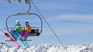 Two skiers sitting in ski lift
