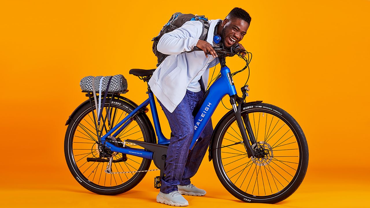 Raleigh Motus electric bike on an orange studio backdrop