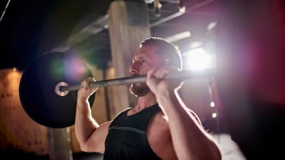 Man about to perform a barbell shoulder press