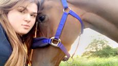 A close-up of a rider hugging a horse