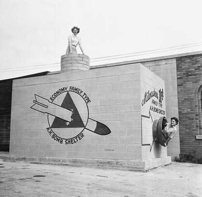 Two women emerge from a new family bomb shelter on display in Milwaukee, Wisconsin.