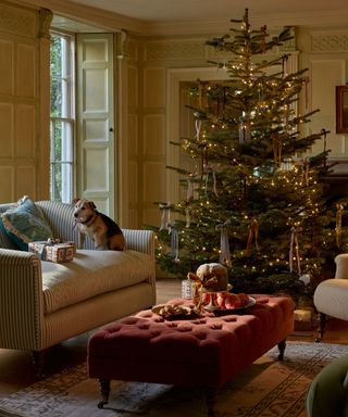 cottage english living room with large christmas tree covered in ribbon bows