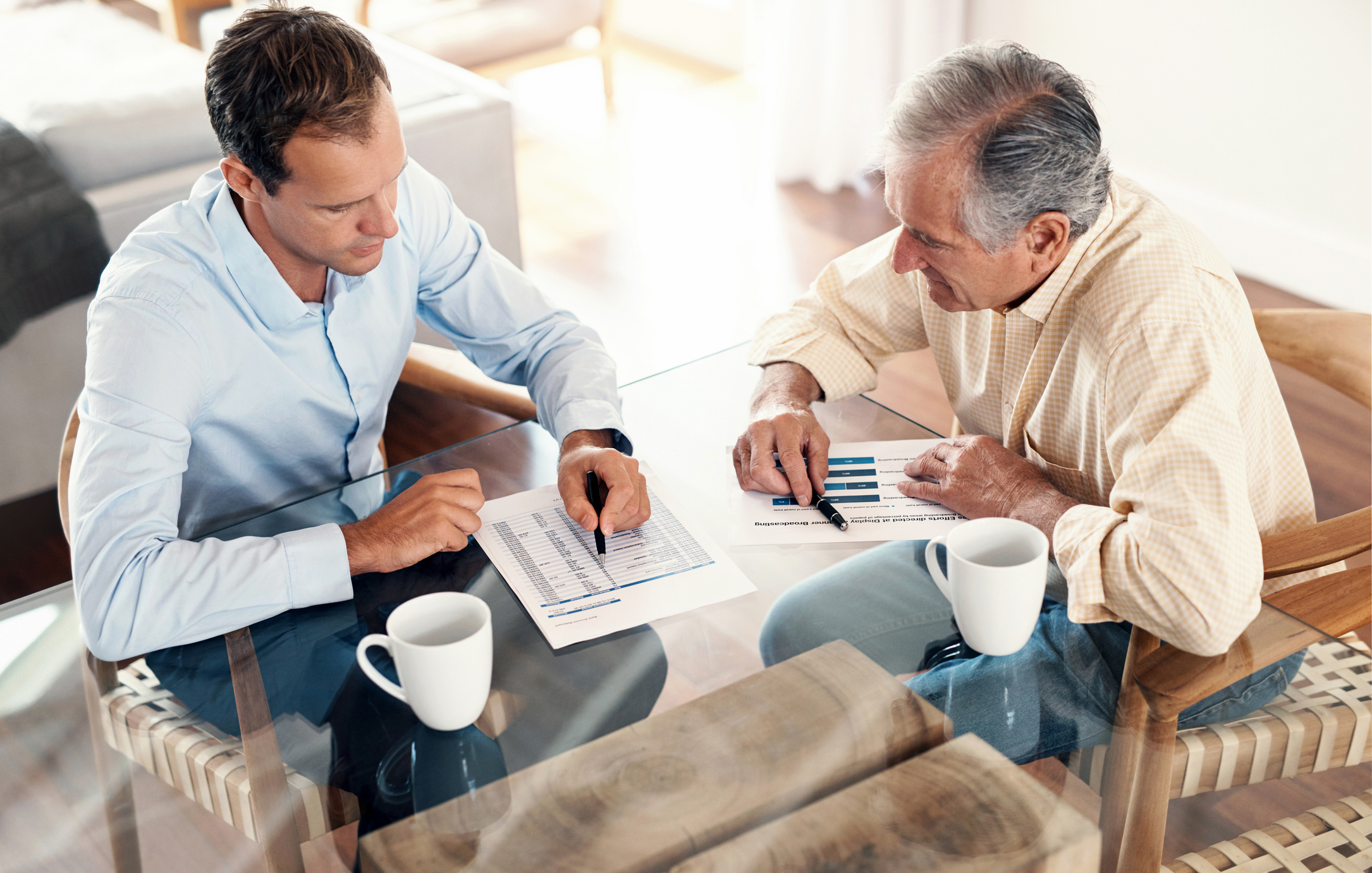 An insurance broker is going over auto insurance quotes with his client.