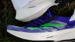 A close up view of the soles of the Nike Air Zoom Tempo NEXT% vs Adidas Adizero Adios Pro 2.0 running shoes