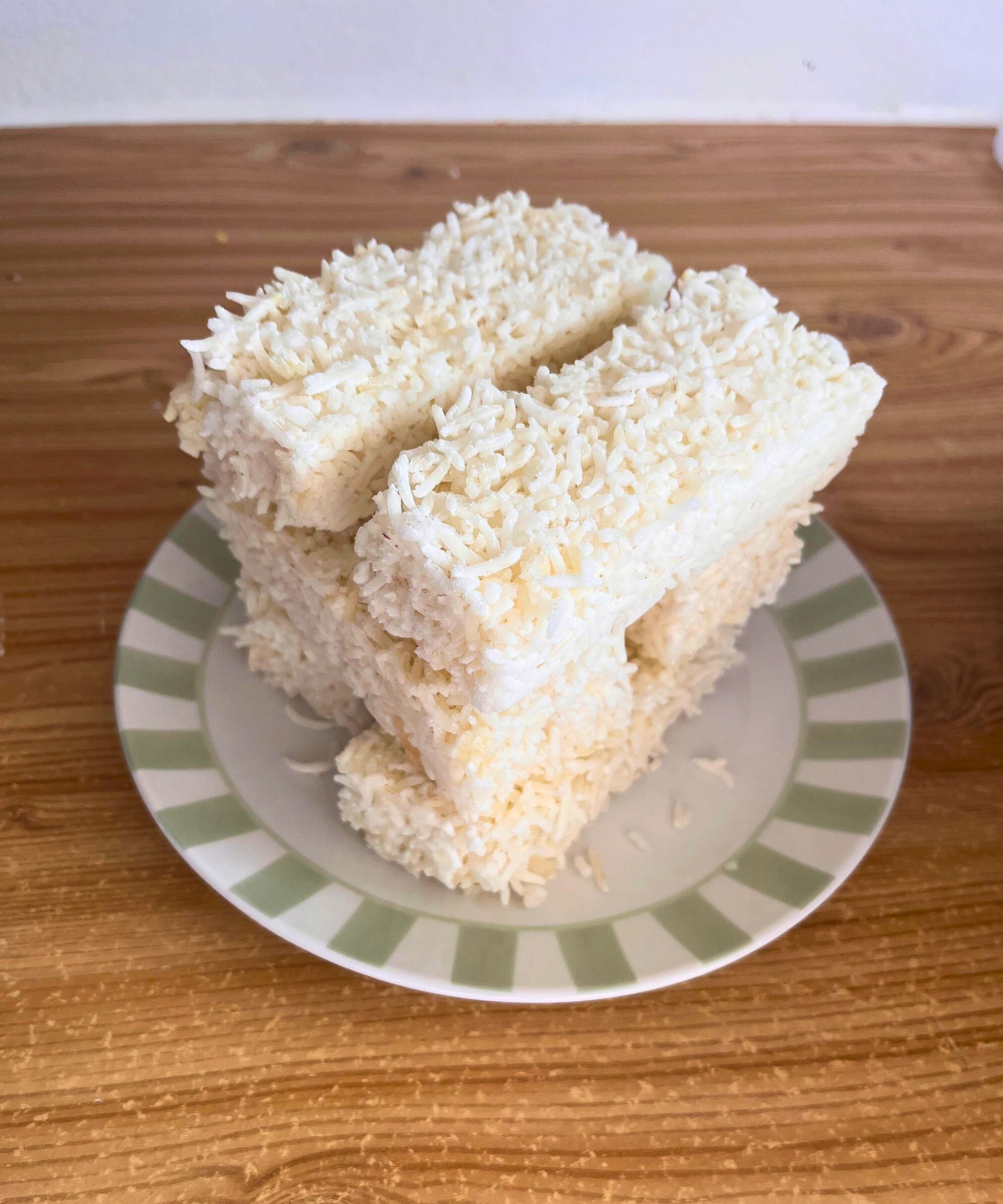 Multiple stacked blocks of frozen white rice on a side plate