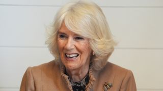 Queen Camilla tries her hand at crafting a spring wreath during a visit to the recently restored Shrewsbury Flaxmill Maltings
