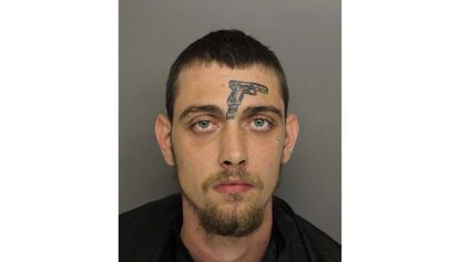 A man with a tattoo of a gun on his forehead has been arrested